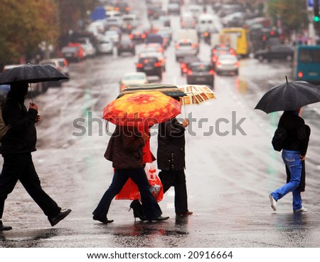 urban people cross the street on the rain