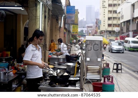 KUALA LUMPUR, MALAYSIA - MARCH 17: Local man cooks fast food on the street in Kuala Lumpur\'s Chinatown on March 17, 2011 in Kuala Lumpur. KL Chinatown is popular tourist attraction and a food haven