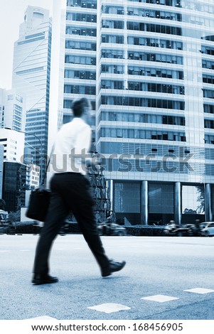 Unidentified businessman crossing the street in Singapore. There are more than 7,000 multinational corporations from US States, Japan and Europe in Singapore
