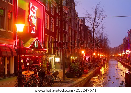 AMSTERDAM, NETHERLANDS - MARCH 10, 2013: Red-light district in Amsterdam. There are about three hundred cabins rented by prostitutes in the area.