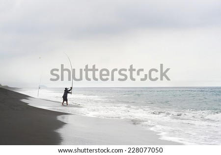 NUSA DUA, BALI, INDONESIA - APRIL 27, 2012: Traditional Balinese fisherman fishing with long rods on the beach in Nusa Dua.