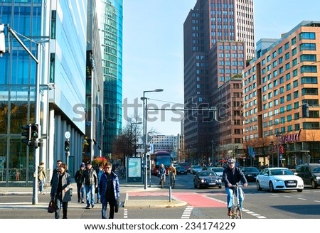 BERLIN, GERMANY - NOV 15, 2014: People crossing the street at Potsdamer Platz -  important public square and traffic intersection in the centre of Berlin, most bustling traffic intersection in Europe