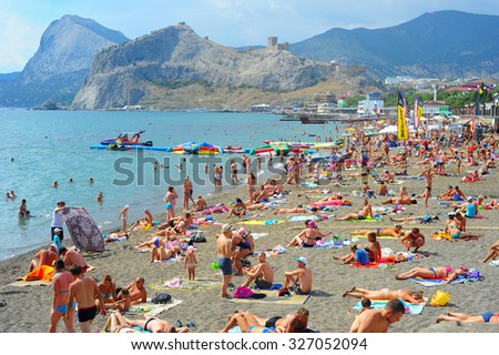 SUDAK, UKRAINE - SEPT 08, 2015: People at a sea beach in Sudak. According to National Geographic, Crimea was among the top 20 travel destinations in 2013