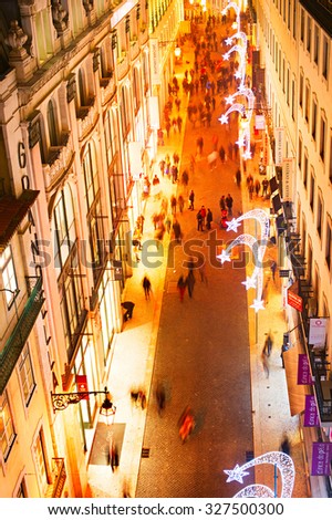LISBON, PORTUGAL - DECEMBER 22, 2014: People on the shopping street in downtown of Lisbon in the evening. Portugal are visiting more than 7 million tourists each year.
