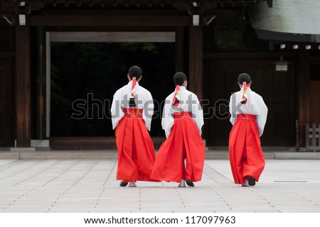 Three Japanese women in traditional outfits walk across the square of a temple in Yoyogi Park, Tokyo.