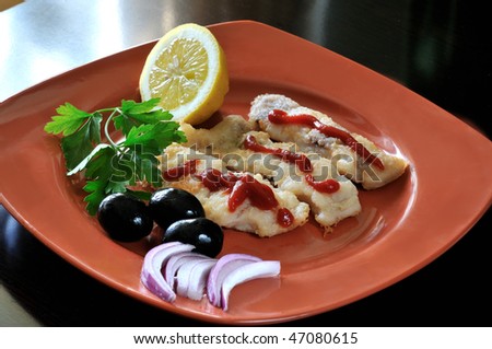 Roasted fillet of bass with olives, lemon and onion in a terracotta dish