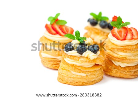 homemade puff pastry stuffed with cream and berries on white