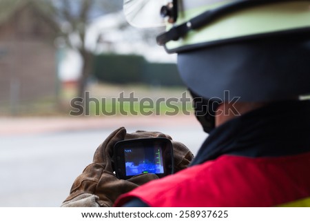 Firefighter with in action thermal camera