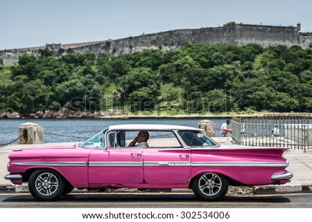 HAVANA, CUBA - JULY 05, 2015: HDR pink american classic car parked on the promenade in Havana