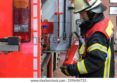 Firefighter with extinguisher on the firetruck