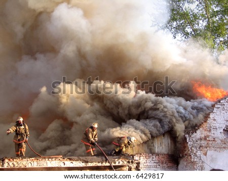 Firefighters in the roof trying to control a fire.