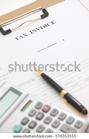 Business document of tax invoice form with pen and calculator