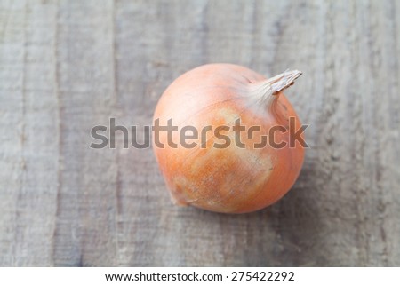 Small fresh gold onion on wood background