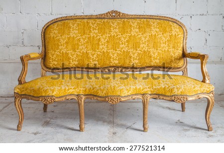 Vintage luxury yellow sofa with white brick wall background