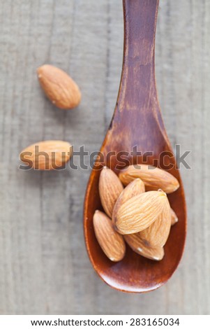 Almond in wood spoon on wood table background