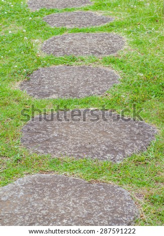 Zen stone path and green grass in a Japanese Garden