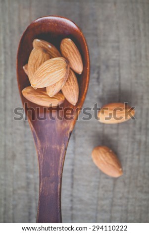 Almond in wood spoon on wood table background