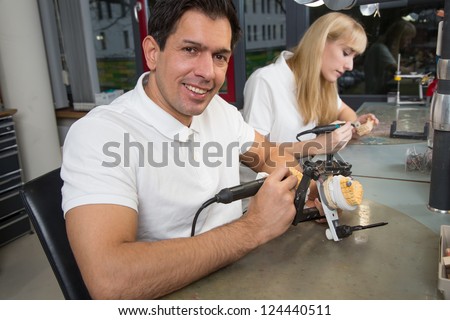 Dental technician working on a dental prosthesis in an articulator