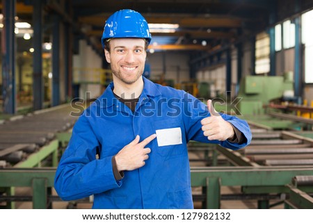 Construction worker with helmet in assembly hall with thumbs up