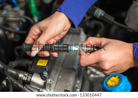 A car mechanic changing spark plugs
