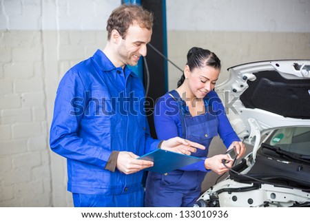 Car mechanics repairing car electrics and other parts of the motor