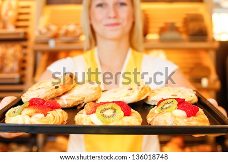 Bakery shopkeeper presents pastry and cakes