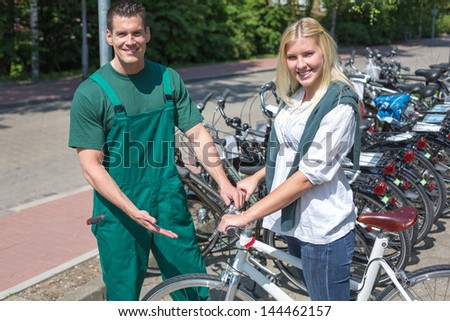 Bicycle mechanic in bike shop consulting an interested customer