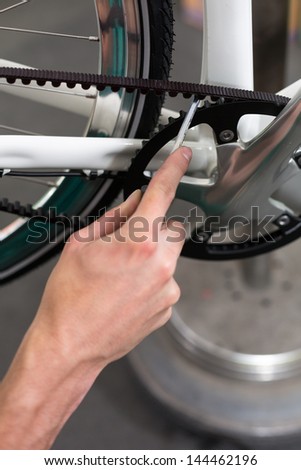 Closeup of bicycle mechanic repairing a bike in workshop