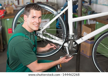 Bicycle mechanic repairing bike in a workshop