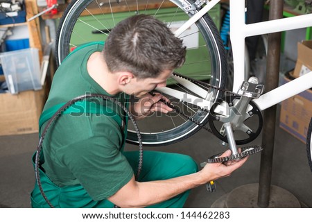 Bicycle mechanic repairing bike in a workshop