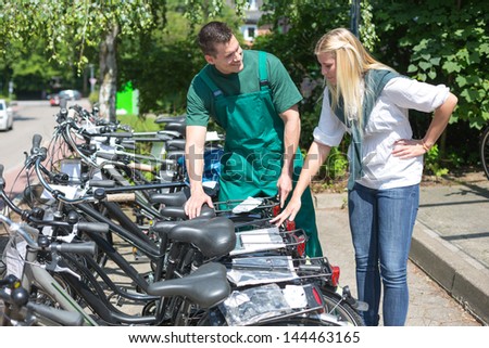 Bicycle presenting a collection of new bikes to customer in cycle shop
