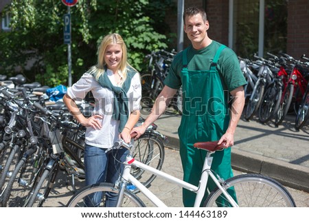 Bicycle mechanic showing a new bike to interested customer