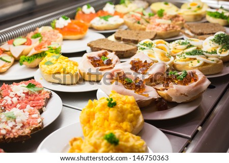 Sandwiches from catering service on plate at a buffet with cold meat, eggs and cheese