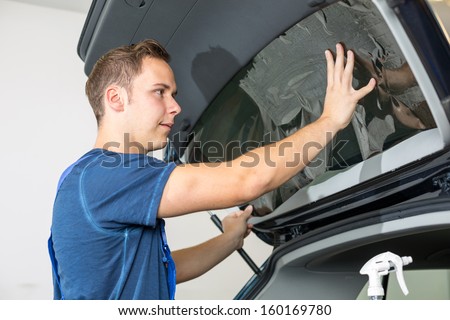 Car Wrappers Tinting A Vehicle Window With A Tinted Foil Or Film Using Heat Gun And Squeegee