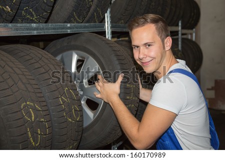 Mechanic in wheel or tire warehouse of a garage