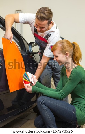 Car branding specialist consults a client about different types of adhesive foils or films for wrapping vehicles