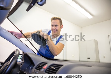 Windshield or windscreen is replaced by glazier on a car in garage after stone-chipping