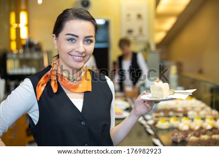 waitress or server presenting cake in cafe