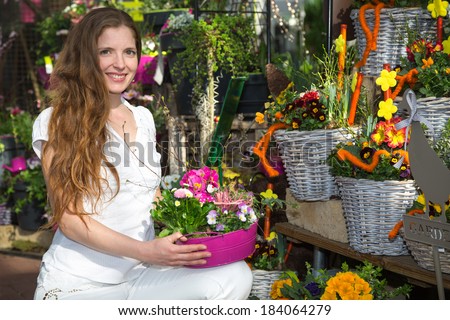 Woman in flower shop among many flower arrangements