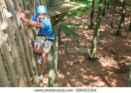 Climber at climbing wall in high rope course