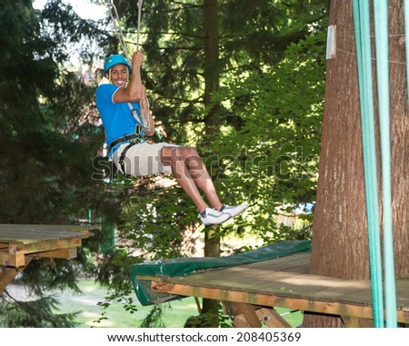 Man sliding on ropeway at high rope course