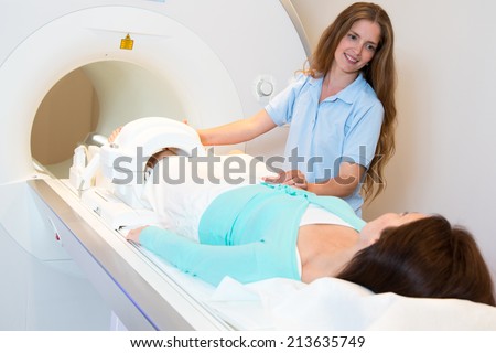 Medical technical assistant councelling patient and preparing scan of the knee with magnetic resonance tomography MRI in radiology