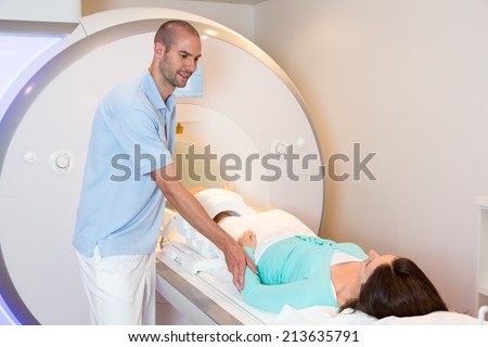 Medical technical assistant councelling patient and preparing scan of the knee with magnetic resonance tomography MRI in radiology