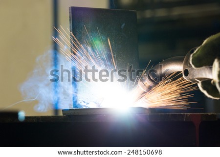 Closeup of welding metal with arc, sparks and torch
