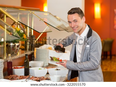 Guest in restaurant putting oil on his salad