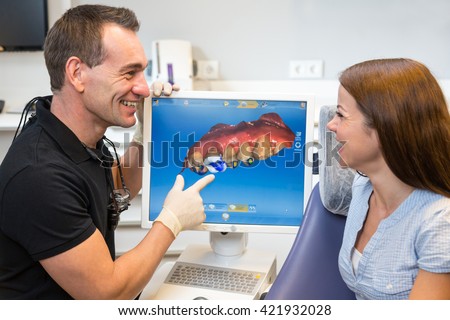Dentist counseling patient about CEREC (Chairside Economical Restoration of Esthetic Ceramics) dental technology