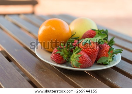 Strawberries, apple and orange on a plate