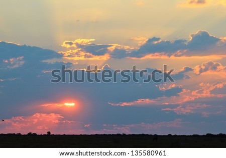 Sunset - Africa and its rays of light that reflect red and golds through the infinite blue skies.