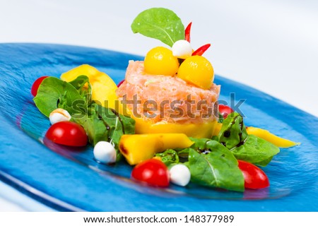 Marinated salmon with yogurt and lemon served with fresh mango,  arugula salad and mozzarella cheese