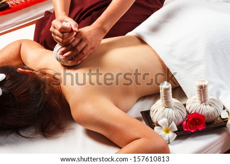 woman with thai herbal compress massage in spa